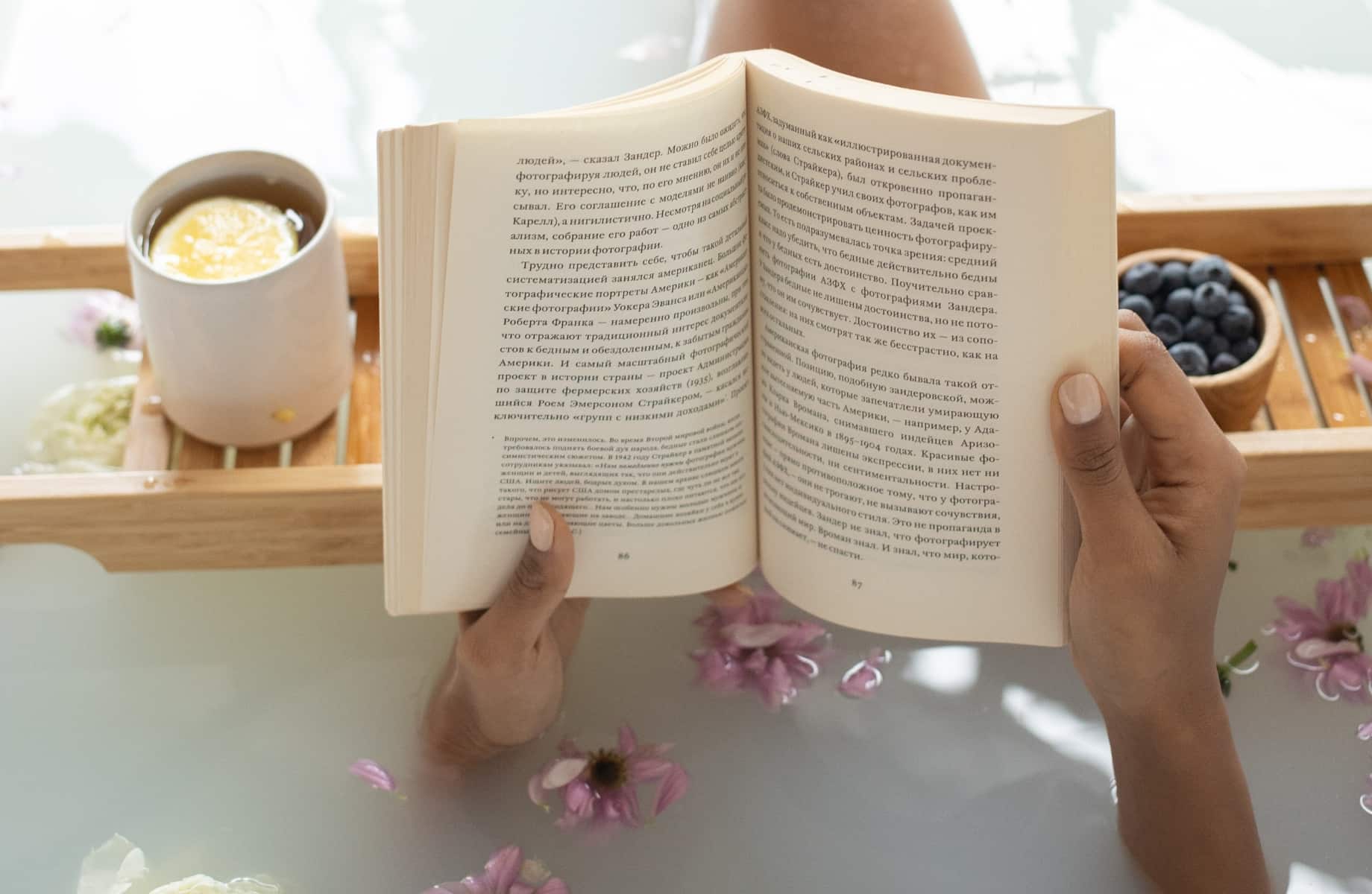 дівчина читає книгу у ванній кімнаті